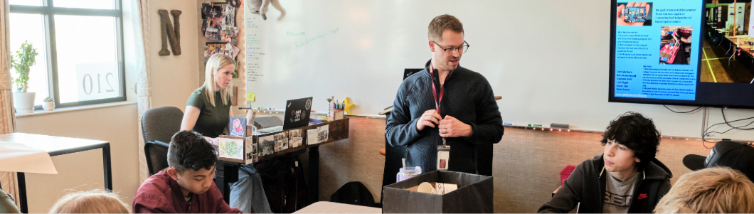 A group of middle school students work on a project in a classroom.