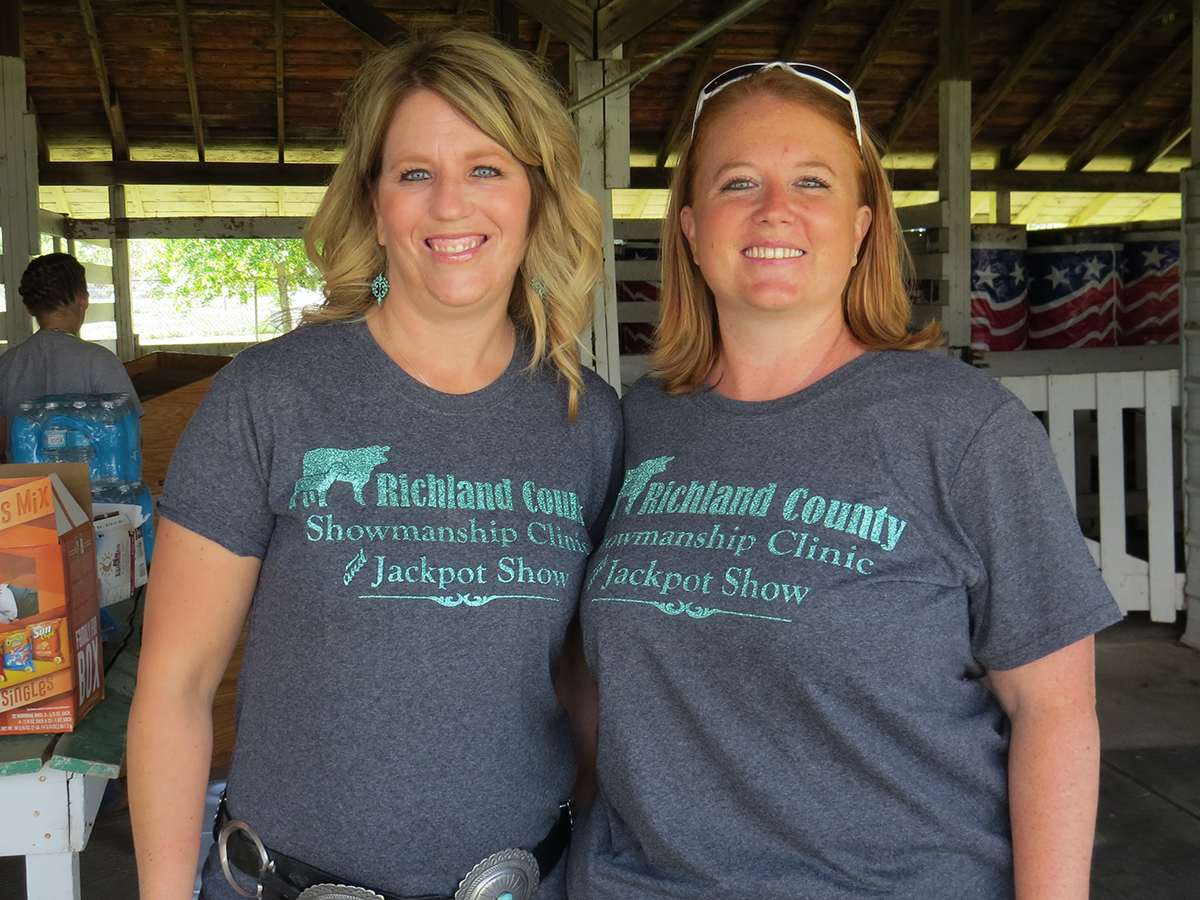 Two women standing with an arm around each other smiling to the camera