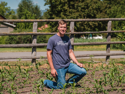 4-H member kneeling in a garden