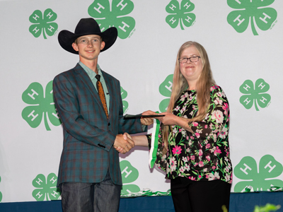 4-H member being handed a certificate at 4-H Congress