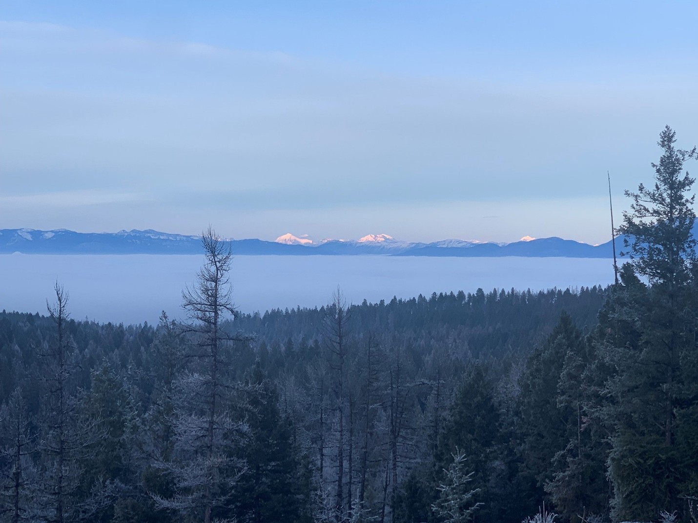 An inversion layer completely blankets the Flathead Valley with snowy peaks of Glacier National Park in the distance.