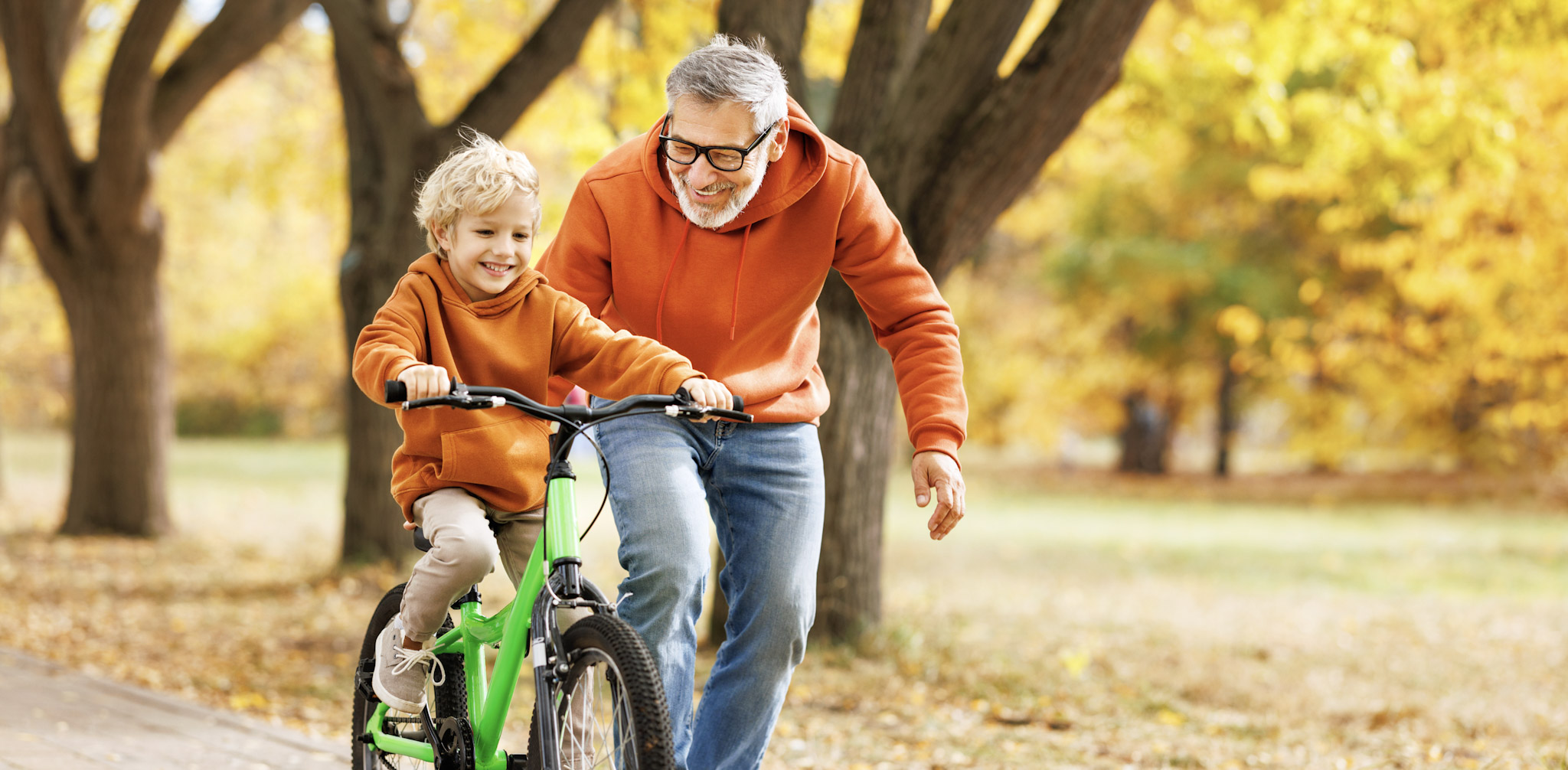 Man teaching kid how to use bike