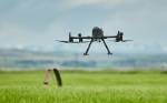Small drone hovers over a pasture as part of a geospatial skills camp